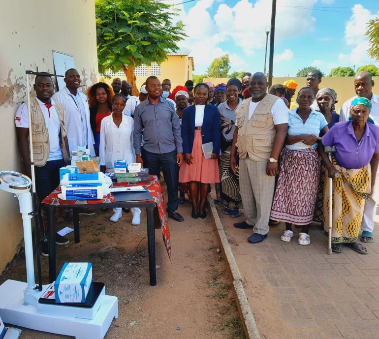 Grupo de voluntarios e idosos pousando para foto com as doacoes de medicamentos